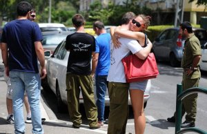 Reserve soldier says farewell to his girlfriend at a mobilization point in Haifa. Photo by Rami Shalosh, Ha'aretz online, 18 July 2014.