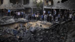 Palestinian men gather around a crater caused by an Israeli air strike on the al-Dalu family's home in Gaza City on November 18, 2012. (AFP Photo / Marco Longari)